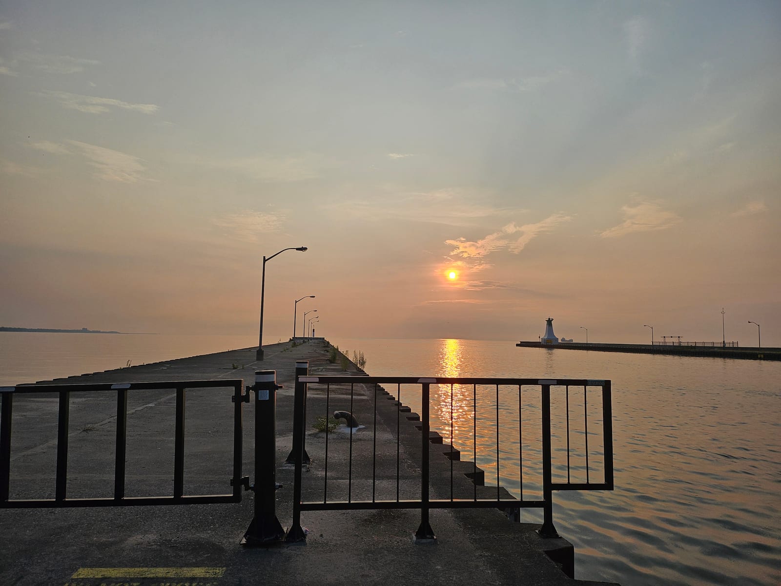 A sunrise next to a lighthouse over lake ontario